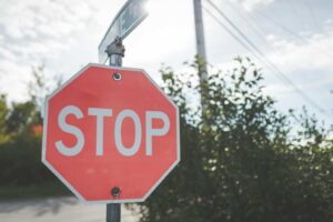 Blog Stopped road sign at intersection with trees in background.